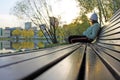 Girl sitting on the edge of a wooden bench in the city Park Royalty Free Stock Photo