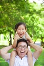 Girl sitting father shoulder and make a funny facial expression