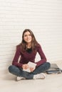 Girl sitting on the floor against a brick wall Royalty Free Stock Photo