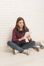 Girl sitting on the floor against a brick wall Royalty Free Stock Photo