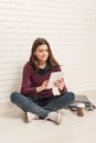 Girl sitting on the floor against a brick wall Royalty Free Stock Photo