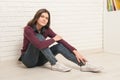 Girl sitting on the floor against a brick wall Royalty Free Stock Photo