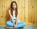 Girl sitting on a floor with crossed legs. Royalty Free Stock Photo