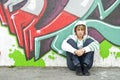 Girl sitting on the floor near graffiti wall