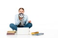 Girl sitting on floor shouting in loudspeaker near laptop, books and copybooks Royalty Free Stock Photo