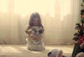 A girl sitting on the floor with two stuffed dogs