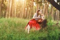 Girl sitting in the forest with a basket of apples in a red long skirt Royalty Free Stock Photo