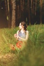 Girl sitting in the forest with a basket of apples in a red long skirt Royalty Free Stock Photo