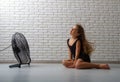 The girl is sitting in front of the fan Royalty Free Stock Photo