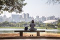 A girl sitting in front of lake with the city as backgroung Royalty Free Stock Photo