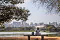 A girl sitting in front of lake with the city as backgroung Royalty Free Stock Photo