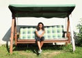 Girl sitting on a garden swing Royalty Free Stock Photo