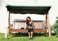 Girl sitting on a garden swing Royalty Free Stock Photo