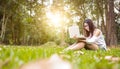 A girl sitting on the grass and hold labtop. She wear grasses. Royalty Free Stock Photo