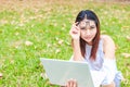 A girl sitting on the grass and hold labtop. She wear grasses. Royalty Free Stock Photo