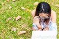 A girl sitting on the grass and hold labtop. She wear grasses. Royalty Free Stock Photo