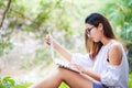 A girl sitting on the grass and hold labtop. She wear grasses. Royalty Free Stock Photo