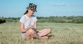 Girl is sitting on the grass in the park and writes in a notebook with a pen. Royalty Free Stock Photo