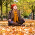 Girl sitting on the ground in park on a sunny fall day