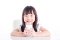 Girl sitting and holding a glass of milk over white