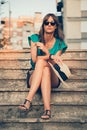 Girl sitting and holding her hat and necklace Royalty Free Stock Photo