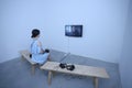 Girl sitting in an interactive room and watching a film on monitor