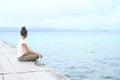 Girl sitting on jetty by sea Royalty Free Stock Photo