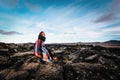 Girl sitting in Krafla volcanic area, Iceland