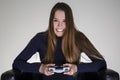 Girl sitting in a leather armchair and holding a video game controller. Royalty Free Stock Photo