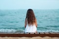 The girl is sitting looking at the sea with her back to the viewer Royalty Free Stock Photo