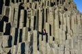 Girl sitting in middle of basalt stone columns on Reynisfjara Royalty Free Stock Photo