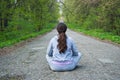 Girl sitting in the middle of a forest road Royalty Free Stock Photo