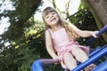 Girl Sitting on monkey bars in backyard portrait