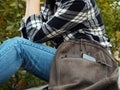 The girl is sitting in nature and waiting for the smartphone to charge from the power Bank. The concept of using modern Royalty Free Stock Photo