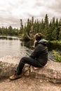 Girl sitting near Lake of two rivers in Algonquin National Park Canada Ontario natural pinetree landscape Royalty Free Stock Photo