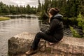 Girl sitting near Lake of two rivers in Algonquin National Park Canada Ontario natural pinetree landscape