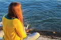 Girl sitting next to the riverbank at sunset in Lisbon