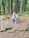 Girl sitting on an old stone bench in the forest in spa resort Marianske Lazne Royalty Free Stock Photo