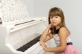 Girl sitting at piano putting her chin on her hand Royalty Free Stock Photo