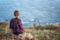 Girl sitting at a picturesque rocky coastline