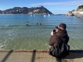 A girl sitting on the pier of Donostia-San Sebastian, Basque Country, City, Spain. The beach of La Concha panoramic view