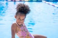 The girl is sitting in the pool area. An african american girl smiling Royalty Free Stock Photo