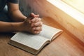 Girl sitting and praying for blessings from god With the Bible folded hands in biblical spiritual and religious prayer,