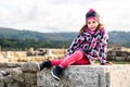 Girl is sitting on remains of ancient roman ruins stone