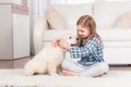 Girl sitting with retriever puppy at home Royalty Free Stock Photo