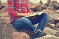 Girl sitting on rock and reading a book Royalty Free Stock Photo