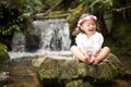 Girl sitting on the rock smiling and with waterfall Royalty Free Stock Photo