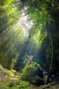 A girl sitting on a rock at Tukad Cepung Waterfall in bali 2