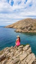 Stara Baska - A girl sitting on a rock with Stara BaskaBeach view