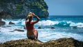 Girl sitting on the Rock and watching Huge Waves hitting Tembeling Coastline at Nusa Penida Island, Bali Indonesia Royalty Free Stock Photo